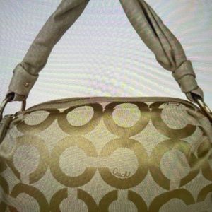 Gold tone coach designer handbag with the brand’s initial C exquisitely bold.